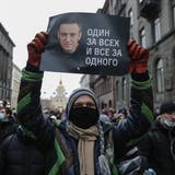 epa08959951 A protester holds a poster that reads 'One for all and all for one', during an unauthorized protest in support of Russian opposition leader and blogger Alexei Navalny, in St. Petersburg, Russia, 23 January 2021. Navalny was detained after his arrival to Moscow from Germany on 17 January 2021. A Moscow judge on 18 January ruled that he will remain in custody for 30 days following his airport arrest. Navalny urged Russians to take to the streets to protest. In many Russian cities mass events are prohibited due to an increasing number of cases of the COVID-19 pandemic caused by the SARS CoV-2 coronavirus.  EPA/ANATOLY MALTSEV (Anatoly Maltsev / EPA)