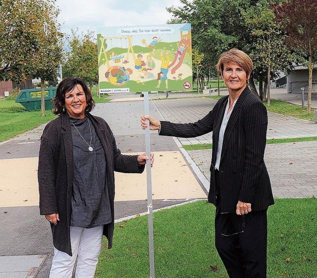 Jolanda Welter Alker (links) und Silvia Troxler beim Schild, das darauf hinweist, dass der Kinderspielplatz eine rauchfreie Zone ist.