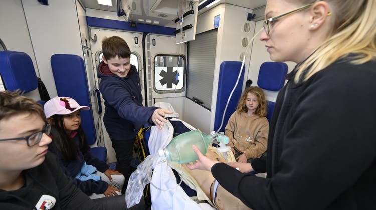 Michèle Kohler erklärt das Innere der Ambulanz und zeigt an einer Puppe Beatmung und Infusion. (Oliver Menge)