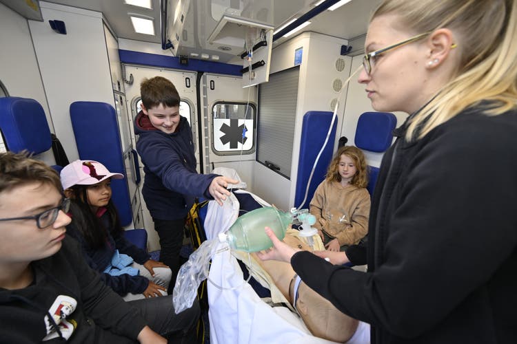 Michèle Kohler erklärt das Innere der Ambulanz und zeigt an einer Puppe Beatmung und Infusion.