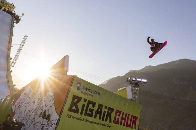 Eine Snowboardfahrerin springt während des Big Air in Chur über eine Schanze.
