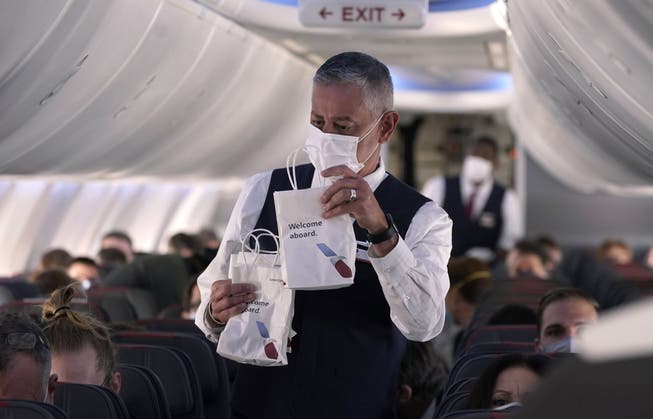 Flugbegleitende bekommen in ihrem Job einiges ab. Hier verteilt ein Steward Snack Bags auf einem Flug der American Airlines. (Symbolbild)