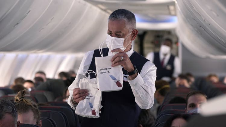 Flugbegleitende bekommen in ihrem Job einiges ab. Hier verteilt ein Steward Snack Bags auf einem Flug der American Airlines. (Symbolbild) (Keystone)