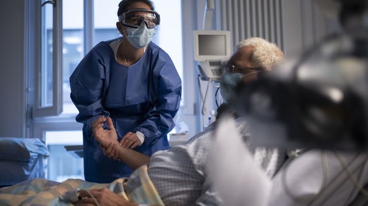 Erschöpft nach zwei Jahren Corona: Eine Pflegefachfrau misst den Puls eines Covid-Patienten in der Isolationsstation des Universitätsspital Zürich. (Christian Beutler / KEYSTONE)