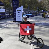 epa09569952 Marcel Hug of Switzerland holds up his flag after winning  the men?ïs wheelchair  division of the 2021 TCS New York City Marathon in New York, New York, USA, 07 November 2021.  EPA/Peter Foley (Peter Foley / EPA)
