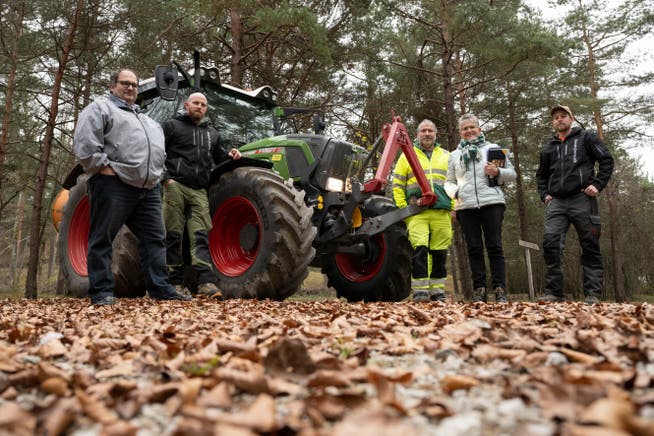 Theo Kern, Geschäftsführer Wald Aargau, Revierförster Martin Blattner, Ueli Windisch, Leiter Unterhalt Densbüren, Vreni Friker, Präsidentin Wald Aargau, und Markus Lüthy, Mitarbeiter Forstbetrieb Jura (von links), vor einem Traktor, der mit einem Laubbläser im Einsatz steht.