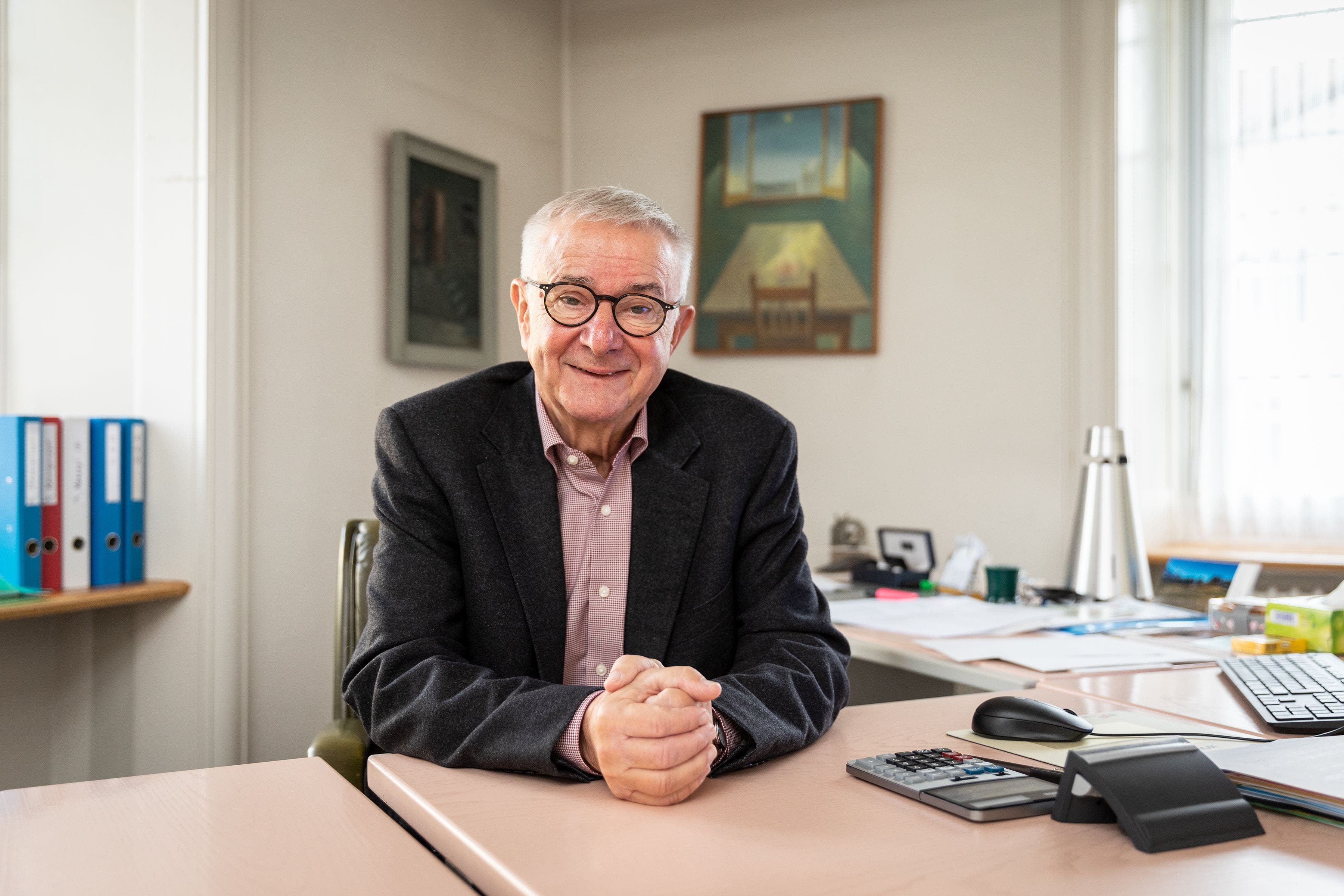 Martin Heiz im November 2021 in seinem Büro im Gemeindehaus Reinach. Das Bild hinter ihm mit Tisch und Stuhl ist sein Lieblingsbild.