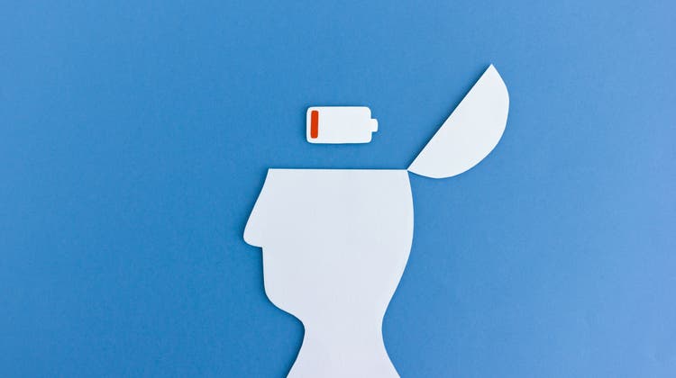 White paper cutout of man with empty battery symbol in opened head on blue background (Misstuni / iStockphoto)