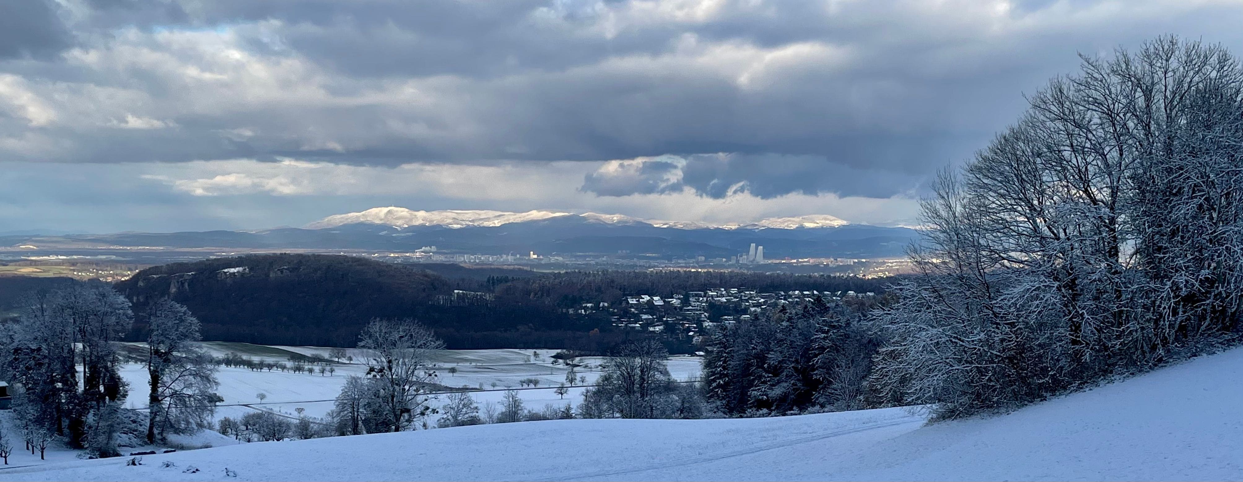Erster Schnee bis ins Basler Becken. Basel mit dem verschneiten Schwarzwald.