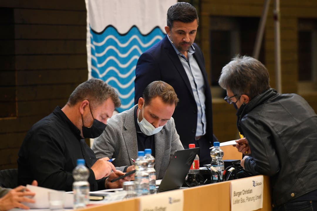 Gemeindeschreiber Daniel Baumgartner (Mitte) nimmt die Resultate der Stimmenzähler entgegen. Beobachtet von Gemeindeammann Andi Meier (rechts, stehend).