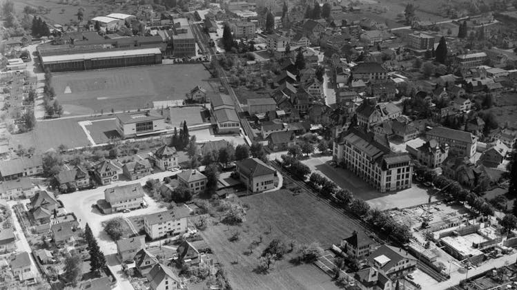 Reinach AG aus der Luft anno 1964. Das Centralschulhaus als markantester Bau, mittig die SBB-Linie. (Comet Photo Ag (zürich) ETH Bildarchiv)