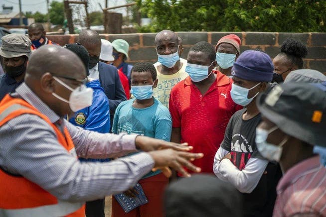 Gautengs Premierminister David Makhura erklärt einer Gruppe Bürgern das neue Impfprogramm Vooma.