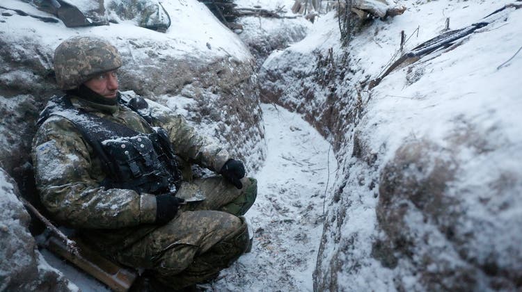 Ein ukrainischer Soldat kauert in einem Schützengraben in der Nähe von Lugansk in einer Aufnahme vom 28. Dezember 2016. Die Schweiz nahm anfangs eine wichtige Rolle bei Verhandlungen zwischen den Kriegsparteien ein. (Vadim Kudinov / EPA)
