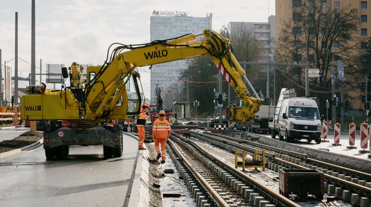 Die Gleise sind gelegt, jetzt muss noch zwischen den Gleisen aufgefüllt werden. Von anfänglich 150 Bauarbeitern sind es inzwischen noch gut 30. Im Hintergrund das Shoppi Tivoli. (Bild: Valentin Hehli (7.12.2021))