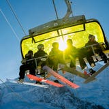 Skifahrer auf einem Sessellift in Wengen. (Bild: Jean-Christophe Bott / Keystone)