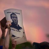 Demonstranten halten während eines Protestes Zettel mit dem Porträt von George Floyd in die Höhe. (Foto: Keystone)