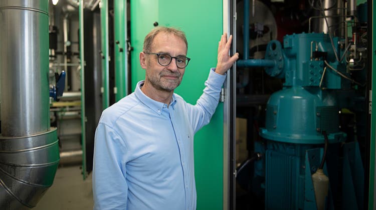 Energiespezialist Stephan Kämpfen vor einer Wärmepumpe im Keller des Buchenhofs in Aarau. (M. Würtenberg)