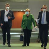 Auf dem Weg zur Pressekonferenz nach der Marathon-Sitzung: Kanzlerin Angela Merkel, CSU-Chef Markus Söder (links) und Berlins Regierender SPD-Bürgermeister Michael Müller (rechts). (Michael Kappeler / AP/23. März 2021)