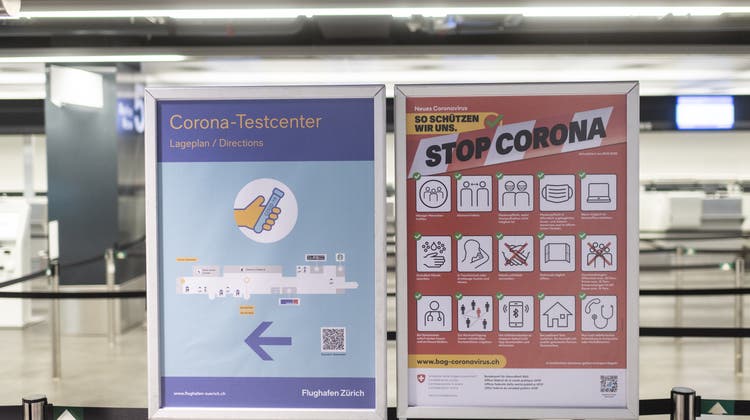 Plakate zeigen den Weg zum Covid-Test am Flughafen in Zürich. (Keystone)