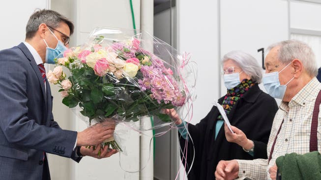 Regierungsrat Lukas Engelberger überreichte Blumen für Lina Arti – sie erhielt die 10'000. Impfung in Basel-Stadt.