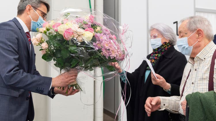 Regierungsrat Lukas Engelberger überreichte Blumen für Lina Arti – sie erhielt die 10'000. Impfung in Basel-Stadt. (Bild: zvg / Photo Basilisk)