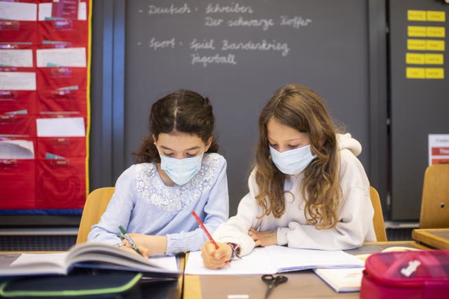 Junge Kinder mit Atemschutzmasken im Unterricht. (Symbolbild)