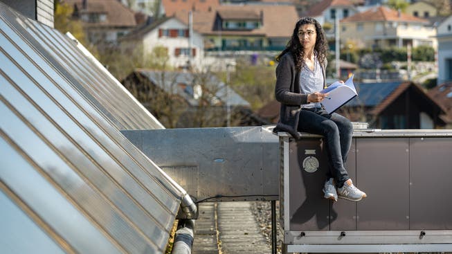 Die Projektleiterin Hochbau der Gemeinde Wohlen, Samanda Cipolla, sitzt auf dem Dach der Turnhalle Junkholz bei der Lüftung und den Sonnenkollektoren.