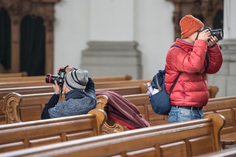 Touristen beim Fotografieren in der St. Galler Stiftskirche.