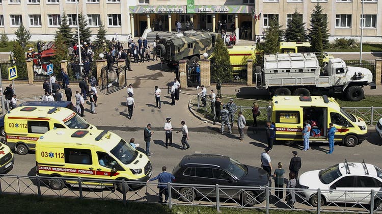 Firefighters walk past ambulances and police cars and a truck parked at a school after a shooting in Kazan, Russia, Tuesday, May 11, 2021. Russian media report that several people have been killed and wounded in a school shooting in the city of Kazan. Russia's state RIA Novosti news agency reported the shooting took place Tuesday morning, citing emergency services. (AP Photo/Roman Kruchinin) (Roman Kruchinin / AP)