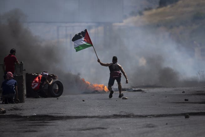 Ein Demonstrant mit der Flagge der Palästinenser: Der Konflikt mit Israel geht Jahrzehnte zurück.