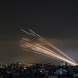 Tödliches Schauspiel am Tel Aviver Nachthimmel: Die Hamas schiesst Raketen aus dem Gazastreifen nach Israel (rechts), Israel lässt Abfangraketen steigen (links). (Bild: Anas Baba/AFP)
