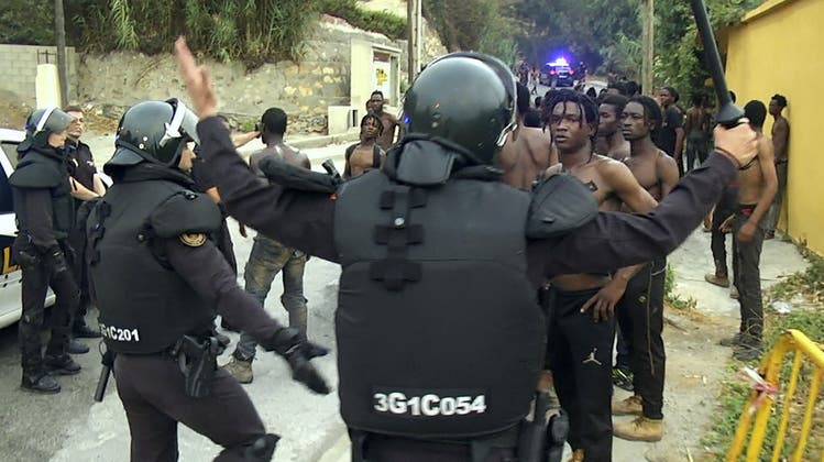 Polizisten der spanischen Guardia Civil drängen Migranten zurück. (Keystone)