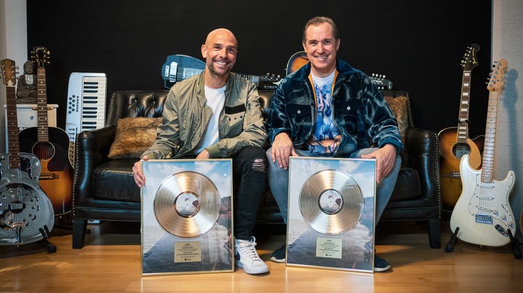 Roger Zeindler alias Roger Martin (rechts) und Maurizio Pozzi alias Maurice freuen sich über die goldene Schallplatte für ihren Hit «Waterfalls». (zvg)