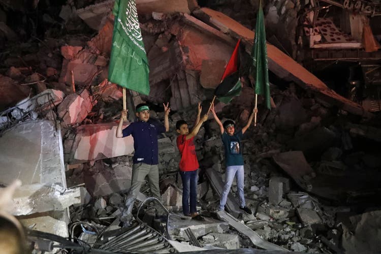 Kinder in Gaza feiern den in der Nacht auf Freitag verkündeten Waffenstillstand. In der Hand halten sie die palästinensische Flagge - und jene der radikalislamischen Hamas.
