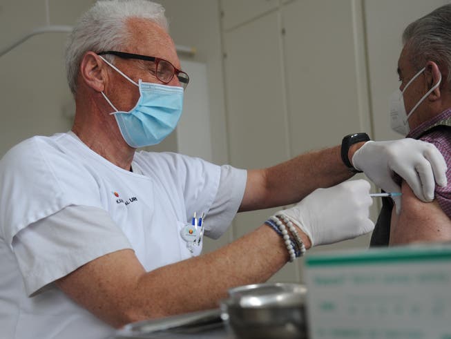 Impfzentrum-Mitarbeiter Peter Raimondo Attenhofer macht eine Covid-19-Impfung.