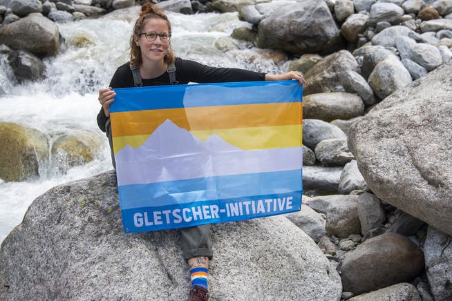 Myriam Roth, Co-Präsidentin des Vereins Klimaschutz, posiert am Tag der Hommage an die Gletscher mit einer Fahne. Schon bald sollen 100'000 dieser Flaggen zur Gletscherinitiative bis in die hintersten Winkel der Schweiz zu sehen sein.