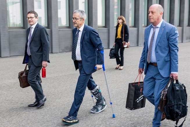 Regierungsrat Thomas Weber geht an Krücken ins Gerichtsgebäude in Muttenz. Begleitet wird er von seinem Anwalt Mark Livschitz (l.) und Regierungssprecher Nic Kaufmann (r.).