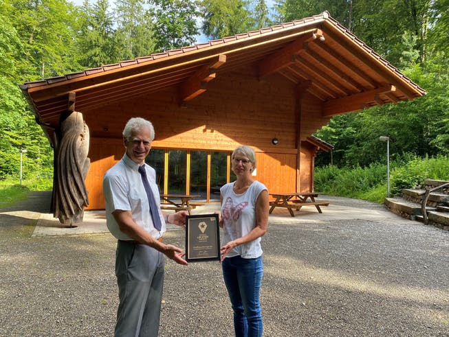 Swiss Location Award: Stadtammann Raymond Tellenbach und Hauswartin Kathrin Keusch bringen das Diplom im Forsthaus an.