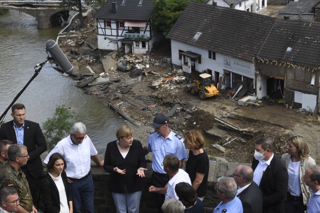 Bundeskanzlerin Angela Merkel (3.v.l hinten CDU) und Malu Dreyer (5.v.l hinten, SPD), Ministerpräsidentin von Rheinland-Pfalz, sprechen mit Helfern und Betroffenen bei ihrem Besuch in den vom Hochwasser verwüsteten Schuld bei Bad Neuenahr-Ahrweiler.