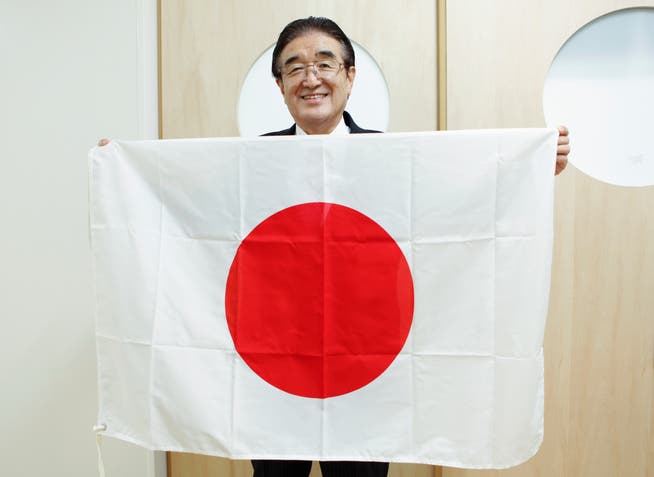 Olympia-Flaggenmeister Tadamasa Fukiura mit der Fahne von  Gastgeber Japan. 