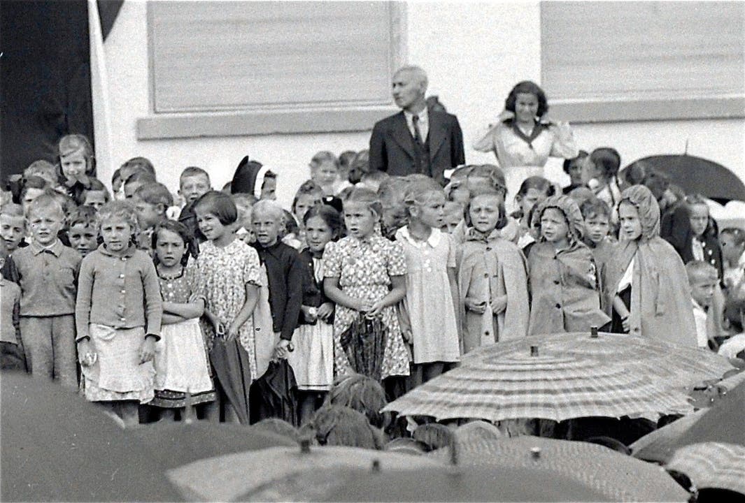 Schulkinder während des Auftritts, hinten Primarlehrer Fritz Stauffacher.