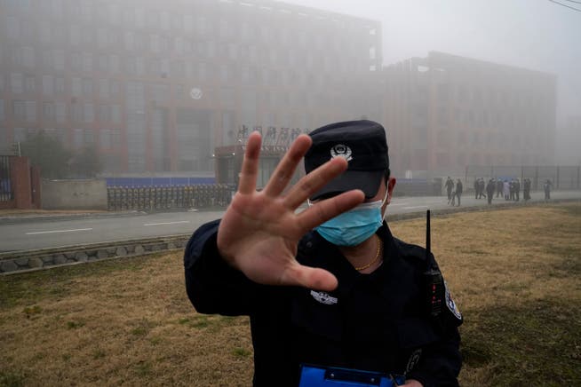 Nix zu sehen! Ein chinesischer Sicherheitsmann verscheucht den Fotografen vor dem Wuhan Institute of Virology.