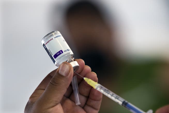 Eine Ampulle des AstraZeneca-Impfstoffs wird aufgezogen. In der Schweiz wird dieser nicht verwendet. Das kann in einigen Fällen zu Konflikten führen.