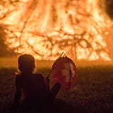 Ein Kind mit Lampion blickt aufs Funkenfeuer. (Bild: PD)