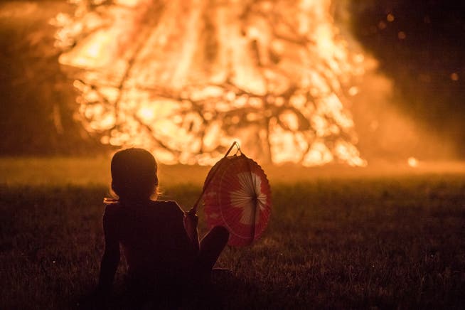 Ein Kind mit Lampion blickt aufs Funkenfeuer.