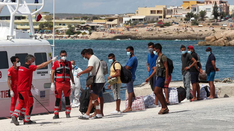 Migranten besteigen ein Schiff der italienischen Küstenwache. (Archivbild September 2020) (AP/Mauro Seminara)