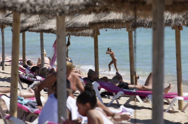Touristen sonnen sich auf Mallorca: Die Insel will trotz steigender Coronazahlen keine neuen Einschränkungen verhängen.