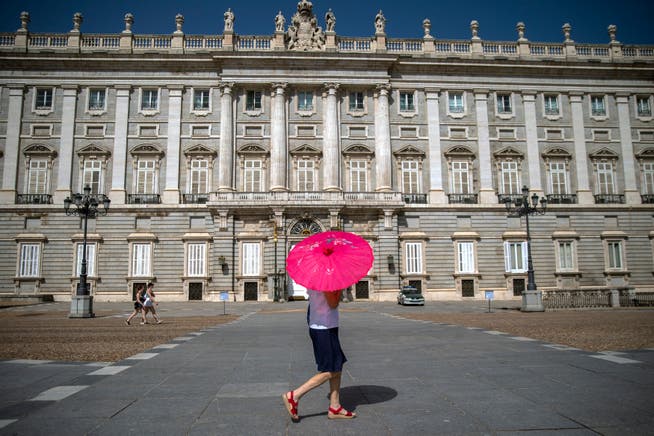 Eine Frau schützt sich in Madrid mit einem Schirm vor der Sonne.