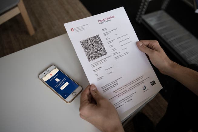 Das Covid-Zertifikat Schweiz wird mit einem Mobiltelefon eingescannt.