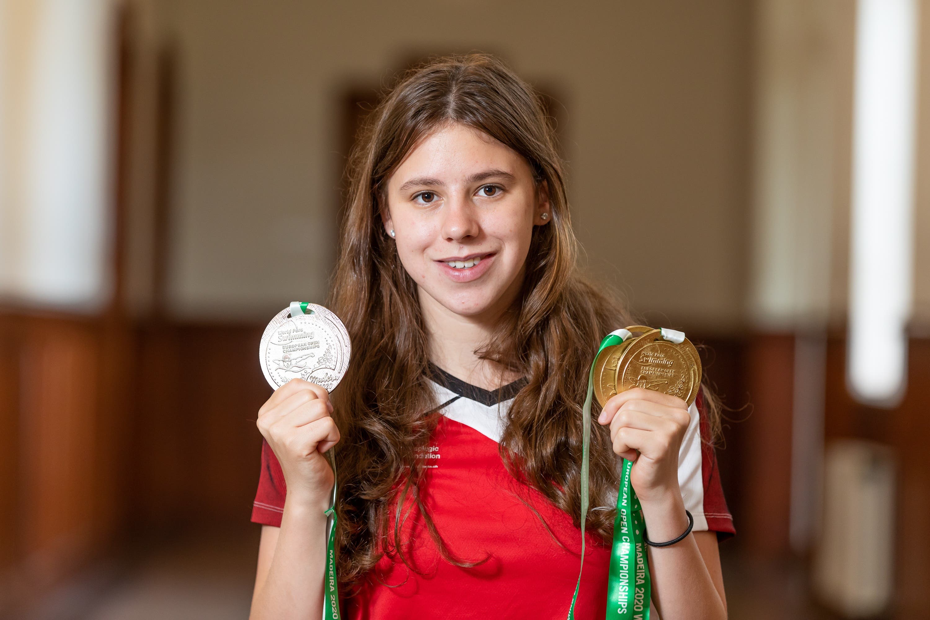 Nora Meister posiert mit ihren drei EM-Medaillen, die sie diese Jahr an der Para-Schwimm-EM gewonnen hat. Dabei schwamm sie auch Welt- und Europarekord.